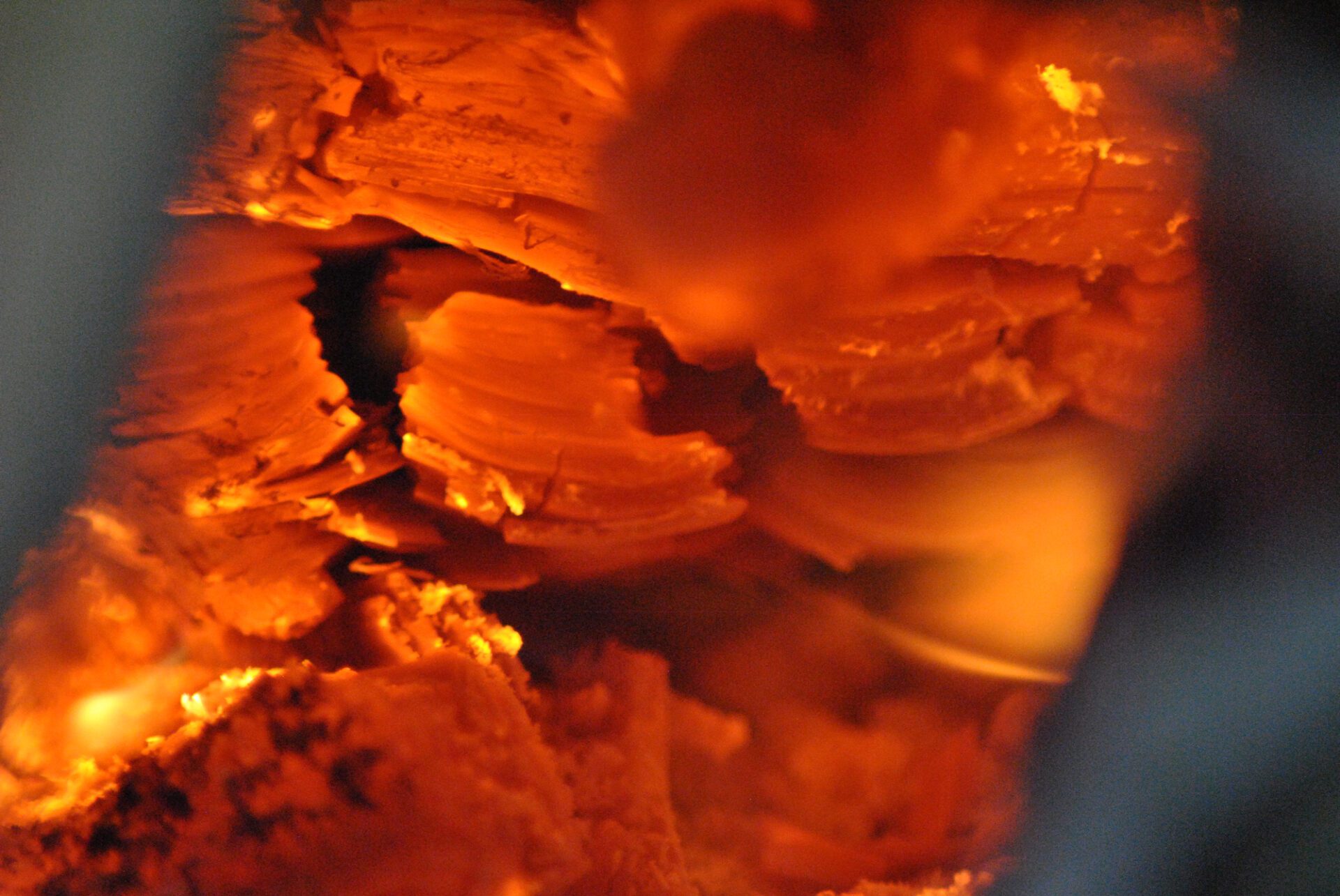 Close-up of glowing orange embers inside a fire